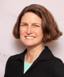 Middle age white female with brunette hair in a teal shirt and black blazer